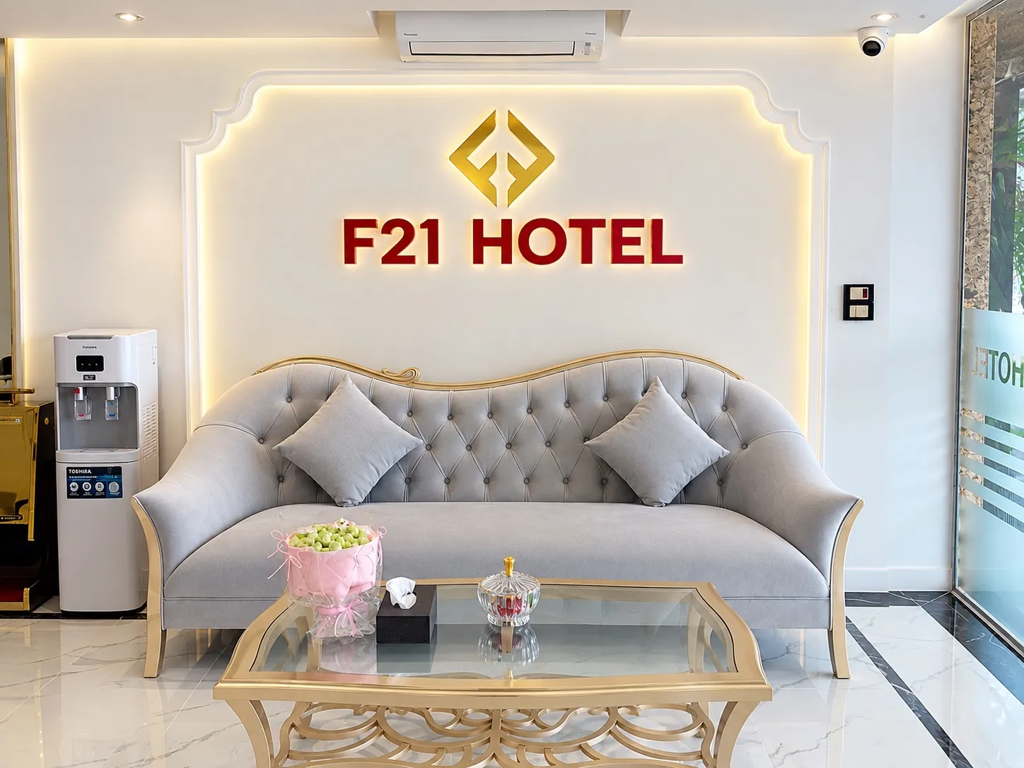 Sofa chờ ở sảnh với biển F21 Hotel